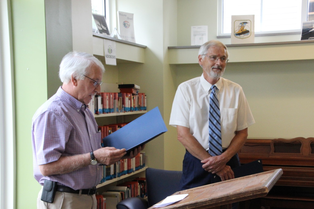 West Virginia State Delegate Walter Duke (R-Berkeley, 61) reads the Certificate of Recognition presented by the Senate of West Virginia to Roger Engle at a ceremony held at Hedgesville Public Library on June 20, 2015 to honor the award-winning, West Virginia author. | Photo by Stephanie Engle